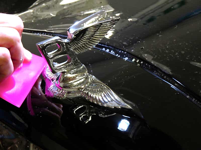 Applicazione della pellicola protettiva auto attorno al logo Bentley sul cofano